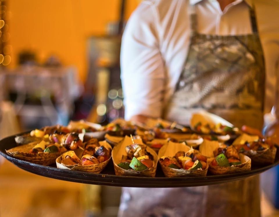 A server carrying freshly prepared savoury bites at an event