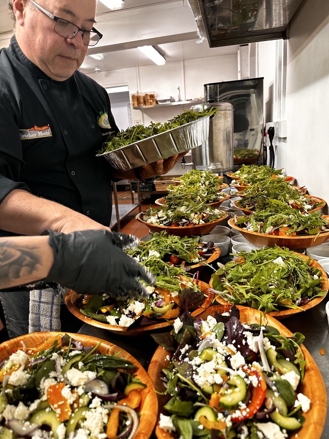 Chef preparing fresh salads for a Challas event